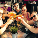 seven people smiling at the camera toasting with beer fork & walk queer tour